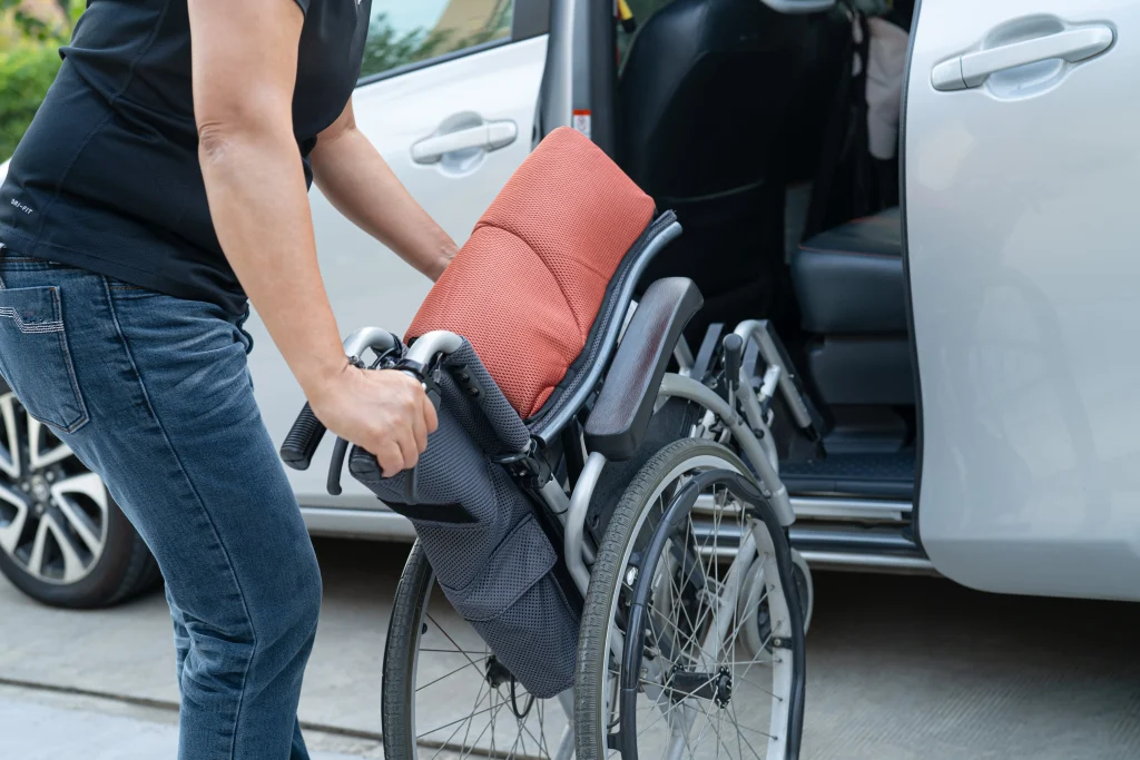 asian-woman-folding-and-lift-up-wheelchair-into-he-2025-02-24-18-00-09-utc-min