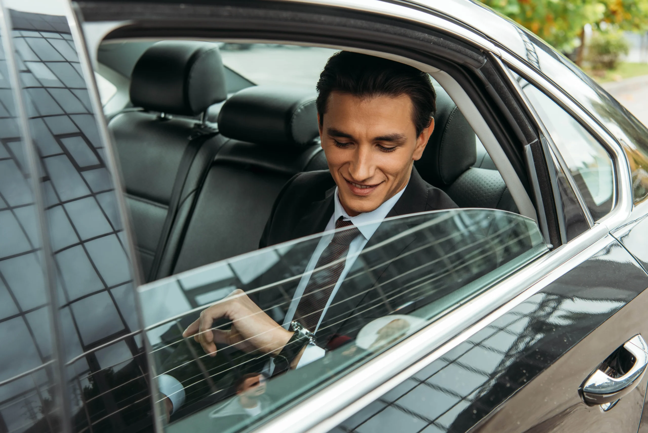 smiling-businessman-looking-at-wristwatch-in-taxi-2024-11-10-12-12-43-utc-min